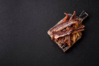 Atıştırmalık olarak kurutulmuş balık veya kurutulmuş et, dilimlenmiş deniz ürünleri. Tasarımınız için arka plan olarak kurutulmuş deniz ürünleri atıştırmalıkları