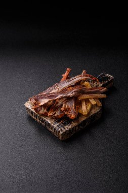 Atıştırmalık olarak kurutulmuş balık veya kurutulmuş et, dilimlenmiş deniz ürünleri. Tasarımınız için arka plan olarak kurutulmuş deniz ürünleri atıştırmalıkları