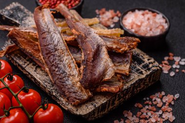 Atıştırmalık olarak kurutulmuş balık veya kurutulmuş et, dilimlenmiş deniz ürünleri. Tasarımınız için arka plan olarak kurutulmuş deniz ürünleri atıştırmalıkları