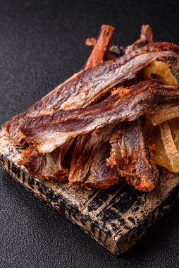 Atıştırmalık olarak kurutulmuş balık veya kurutulmuş et, dilimlenmiş deniz ürünleri. Tasarımınız için arka plan olarak kurutulmuş deniz ürünleri atıştırmalıkları