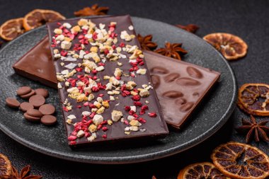 Evde kurutulmuş meyveli çikolatalı bir çikolata. Tasarımınız için arka plan olarak çikolatayı kullanın