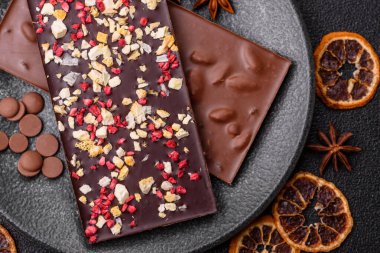 Evde kurutulmuş meyveli çikolatalı bir çikolata. Tasarımınız için arka plan olarak çikolatayı kullanın