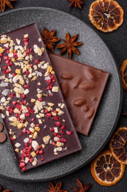 Evde kurutulmuş meyveli çikolatalı bir çikolata. Tasarımınız için arka plan olarak çikolatayı kullanın