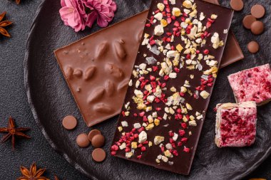 Evde kurutulmuş meyveli çikolatalı bir çikolata. Tasarımınız için arka plan olarak çikolatayı kullanın