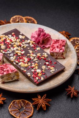 Evde kurutulmuş meyveli çikolatalı bir çikolata. Tasarımınız için arka plan olarak çikolatayı kullanın