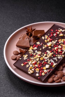 Evde kurutulmuş meyveli çikolatalı bir çikolata. Tasarımınız için arka plan olarak çikolatayı kullanın