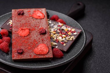 Evde kurutulmuş meyveli çikolatalı bir çikolata. Tasarımınız için arka plan olarak çikolatayı kullanın