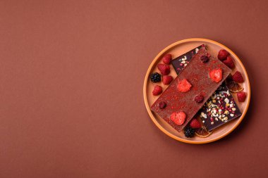 Evde kurutulmuş meyveli çikolatalı bir çikolata. Tasarımınız için arka plan olarak çikolatayı kullanın