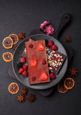 Evde kurutulmuş meyveli çikolatalı bir çikolata. Tasarımınız için arka plan olarak çikolatayı kullanın