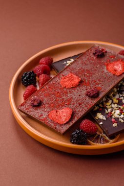Evde kurutulmuş meyveli çikolatalı bir çikolata. Tasarımınız için arka plan olarak çikolatayı kullanın
