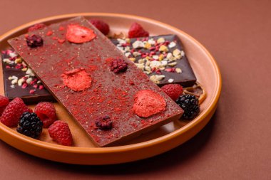 Evde kurutulmuş meyveli çikolatalı bir çikolata. Tasarımınız için arka plan olarak çikolatayı kullanın