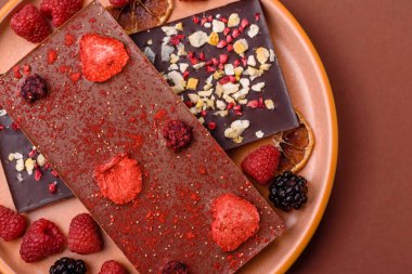 Evde kurutulmuş meyveli çikolatalı bir çikolata. Tasarımınız için arka plan olarak çikolatayı kullanın