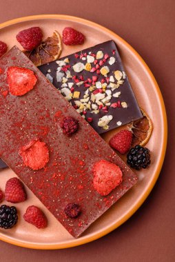 Evde kurutulmuş meyveli çikolatalı bir çikolata. Tasarımınız için arka plan olarak çikolatayı kullanın