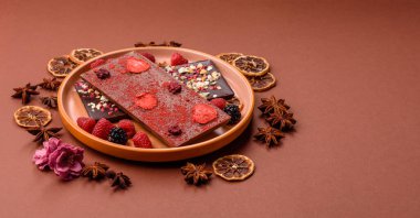 Evde kurutulmuş meyveli çikolatalı bir çikolata. Tasarımınız için arka plan olarak çikolatayı kullanın