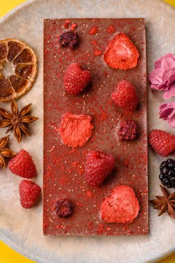 Evde kurutulmuş meyveli çikolatalı bir çikolata. Tasarımınız için arka plan olarak çikolatayı kullanın