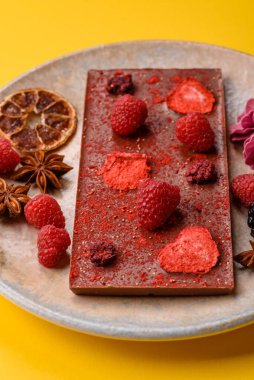 Evde kurutulmuş meyveli çikolatalı bir çikolata. Tasarımınız için arka plan olarak çikolatayı kullanın