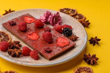 Evde kurutulmuş meyveli çikolatalı bir çikolata. Tasarımınız için arka plan olarak çikolatayı kullanın