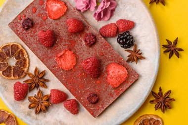 Evde kurutulmuş meyveli çikolatalı bir çikolata. Tasarımınız için arka plan olarak çikolatayı kullanın