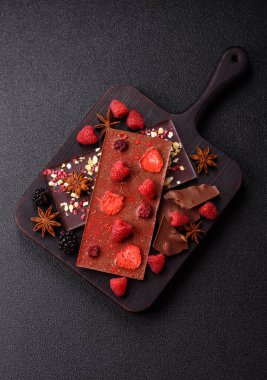 Evde kurutulmuş meyveli çikolatalı bir çikolata. Tasarımınız için arka plan olarak çikolatayı kullanın