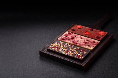 Evde kurutulmuş meyveli çikolatalı bir çikolata. Tasarımınız için arka plan olarak çikolatayı kullanın