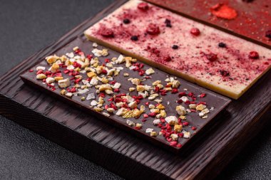 Evde kurutulmuş meyveli çikolatalı bir çikolata. Tasarımınız için arka plan olarak çikolatayı kullanın