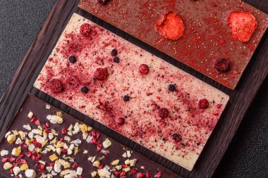 Evde kurutulmuş meyveli çikolatalı bir çikolata. Tasarımınız için arka plan olarak çikolatayı kullanın