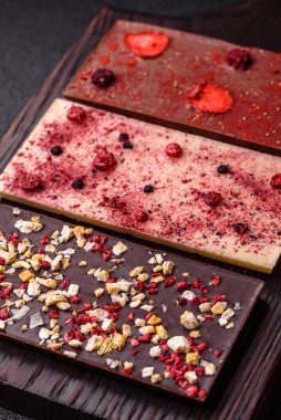 Evde kurutulmuş meyveli çikolatalı bir çikolata. Tasarımınız için arka plan olarak çikolatayı kullanın