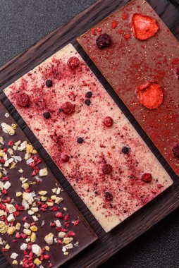 Evde kurutulmuş meyveli çikolatalı bir çikolata. Tasarımınız için arka plan olarak çikolatayı kullanın