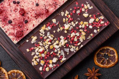 Evde kurutulmuş meyveli çikolatalı bir çikolata. Tasarımınız için arka plan olarak çikolatayı kullanın