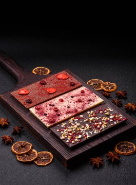 Evde kurutulmuş meyveli çikolatalı bir çikolata. Tasarımınız için arka plan olarak çikolatayı kullanın