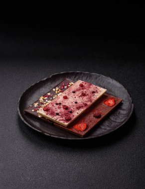 Evde kurutulmuş meyveli çikolatalı bir çikolata. Tasarımınız için arka plan olarak çikolatayı kullanın