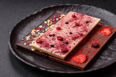 Evde kurutulmuş meyveli çikolatalı bir çikolata. Tasarımınız için arka plan olarak çikolatayı kullanın