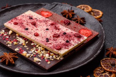 Evde kurutulmuş meyveli çikolatalı bir çikolata. Tasarımınız için arka plan olarak çikolatayı kullanın