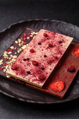 Evde kurutulmuş meyveli çikolatalı bir çikolata. Tasarımınız için arka plan olarak çikolatayı kullanın