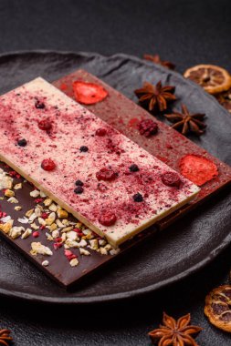 Evde kurutulmuş meyveli çikolatalı bir çikolata. Tasarımınız için arka plan olarak çikolatayı kullanın