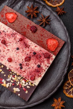 Evde kurutulmuş meyveli çikolatalı bir çikolata. Tasarımınız için arka plan olarak çikolatayı kullanın