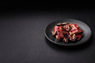 Evde kurutulmuş meyveli çikolatalı bir çikolata. Tasarımınız için arka plan olarak çikolatayı kullanın