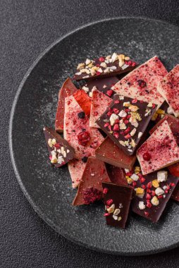 Evde kurutulmuş meyveli çikolatalı bir çikolata. Tasarımınız için arka plan olarak çikolatayı kullanın