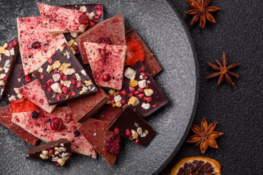 Evde kurutulmuş meyveli çikolatalı bir çikolata. Tasarımınız için arka plan olarak çikolatayı kullanın