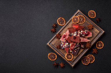 Evde kurutulmuş meyveli çikolatalı bir çikolata. Tasarımınız için arka plan olarak çikolatayı kullanın