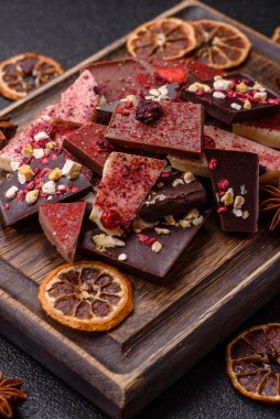 Evde kurutulmuş meyveli çikolatalı bir çikolata. Tasarımınız için arka plan olarak çikolatayı kullanın