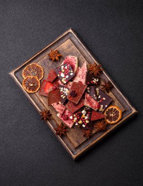 Evde kurutulmuş meyveli çikolatalı bir çikolata. Tasarımınız için arka plan olarak çikolatayı kullanın