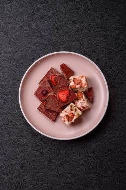 Evde kurutulmuş meyveli çikolatalı bir çikolata. Tasarımınız için arka plan olarak çikolatayı kullanın