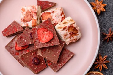 Evde kurutulmuş meyveli çikolatalı bir çikolata. Tasarımınız için arka plan olarak çikolatayı kullanın