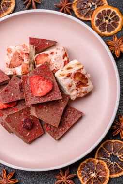 Evde kurutulmuş meyveli çikolatalı bir çikolata. Tasarımınız için arka plan olarak çikolatayı kullanın