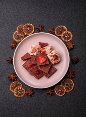 Evde kurutulmuş meyveli çikolatalı bir çikolata. Tasarımınız için arka plan olarak çikolatayı kullanın