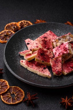 Evde kurutulmuş meyveli çikolatalı bir çikolata. Tasarımınız için arka plan olarak çikolatayı kullanın