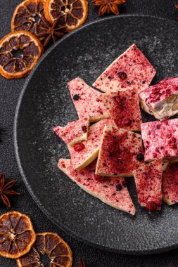 Evde kurutulmuş meyveli çikolatalı bir çikolata. Tasarımınız için arka plan olarak çikolatayı kullanın