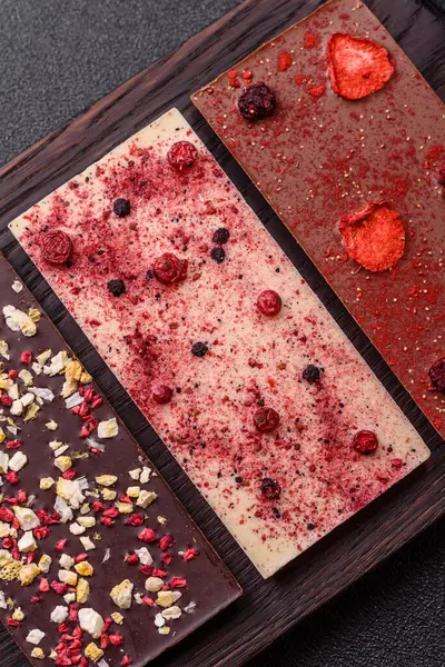 Evde kurutulmuş meyveli çikolatalı bir çikolata. Tasarımınız için arka plan olarak çikolatayı kullanın