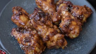 Izgara ya da ızgara tavuk kanadı, teriyaki sosu, baharat ve susam tohumuyla. Koyu arkaplanda tuz ve baharatlı Teriyaki tavuğu